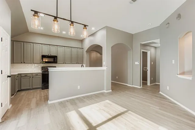 a open kitchen with cabinets a sink and stainless steel appliances