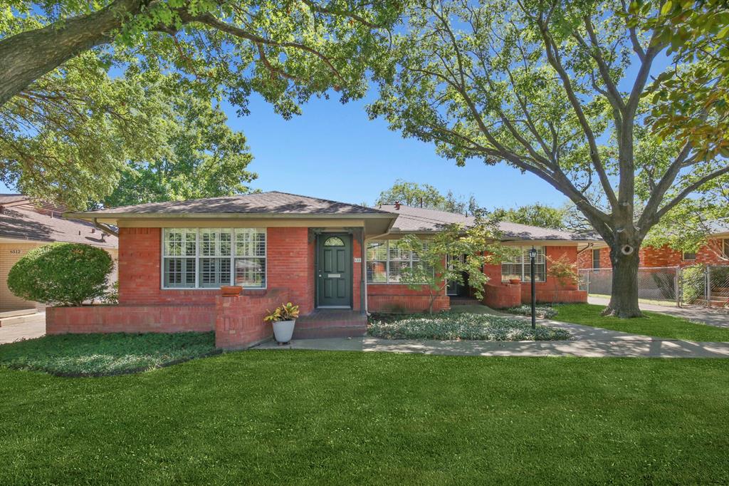 a front view of house with yard and green space
