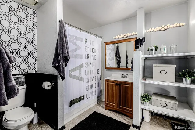 a bathroom with a toilet a sink and a mirror