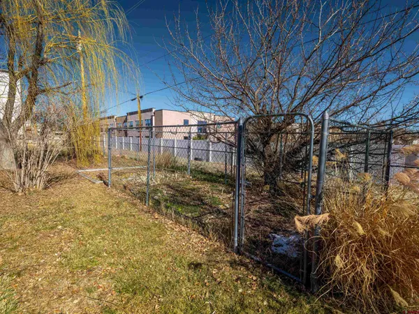 a view of a yard with wooden fence