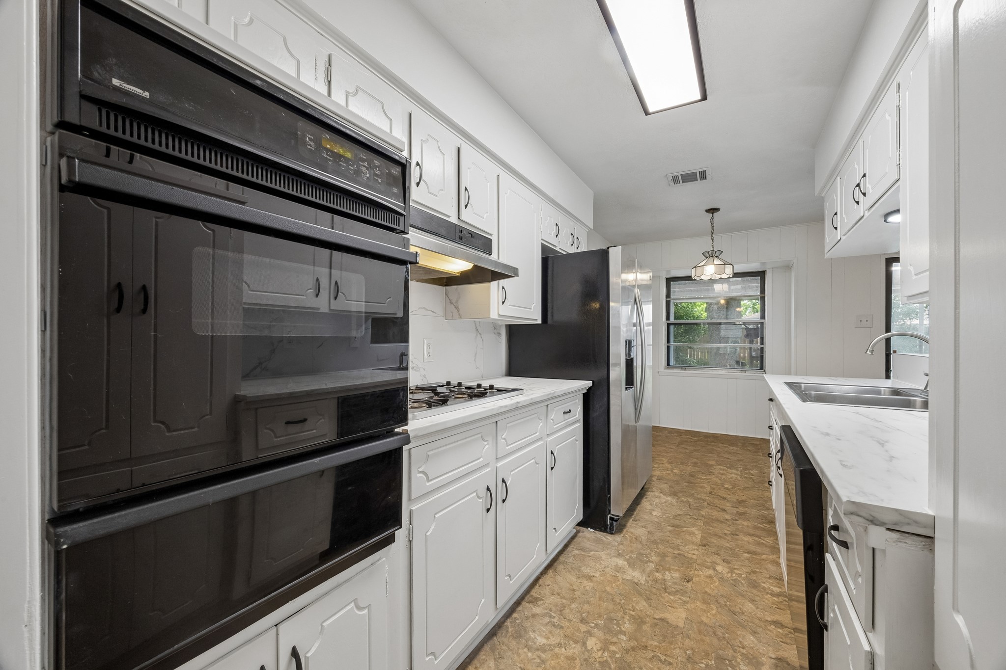 4903 Mistletoe Road Pasadena, TX 77505 - Photo 3 of 10 a kitchen with stainless steel appliances kitchen island wooden cabinets a stove and a refrigerator