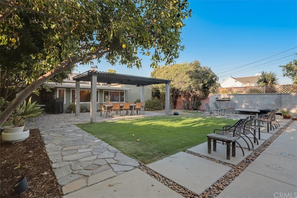 13040 Delano Street Van Nuys, CA 91401 - Photo 41 of 64 a view of a patio with table and chairs potted plants and large tree