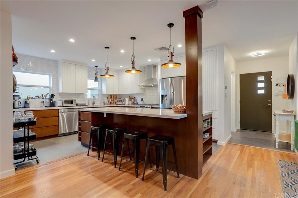 13040 Delano Street Van Nuys, CA 91401 - Photo 9 of 64 a kitchen with stainless steel appliances kitchen island granite countertop a table chairs and a refrigerator