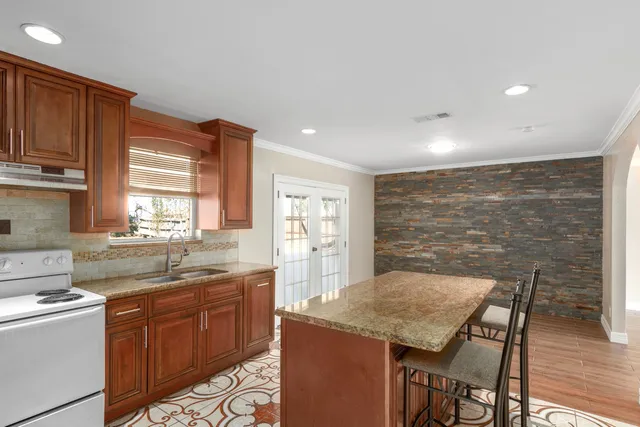 a kitchen with granite countertop a sink and wooden cabinets