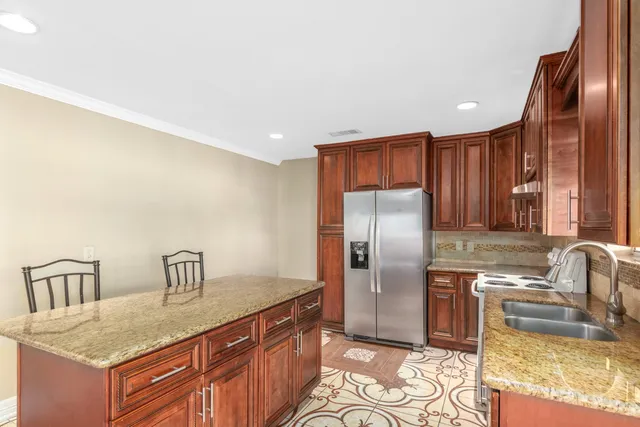 a kitchen with stainless steel appliances granite countertop a sink refrigerator and stove