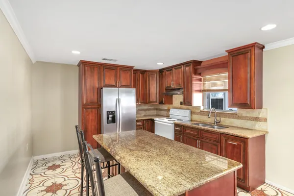a kitchen with stainless steel appliances granite countertop a sink stove and refrigerator