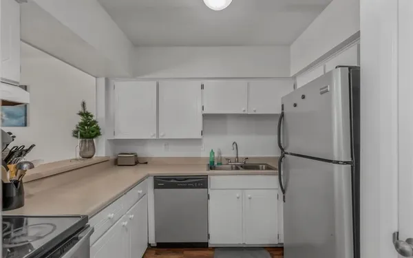 a kitchen with a refrigerator and a white cabinets