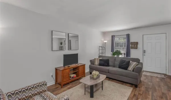 a living room with furniture and a wooden floor