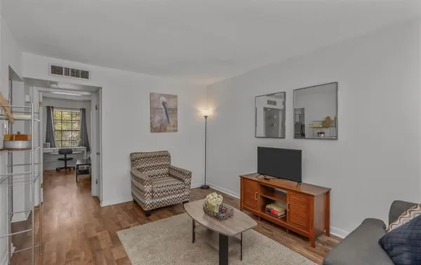 a living room with furniture and a wooden floor