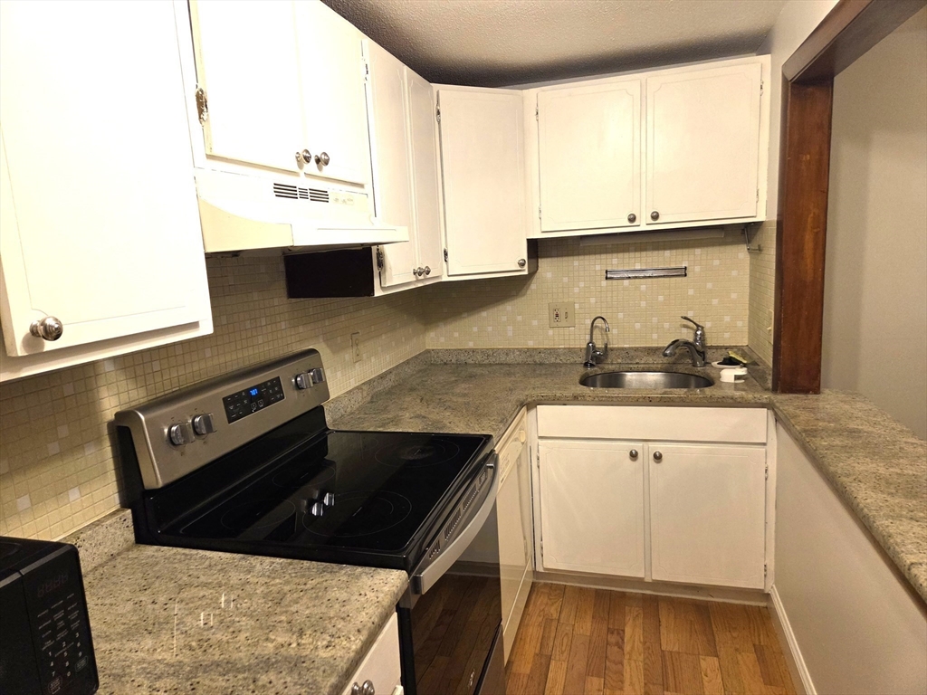 586 Boston Post Road East, Unit 6 Marlborough, MA 01752 - Photo 4 of 17 a kitchen with a stove and a microwave