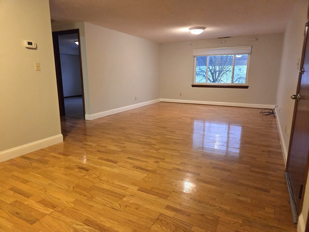 586 Boston Post Road East, Unit 6 Marlborough, MA 01752 - Photo 6 of 17 an empty room with wooden floor and windows
