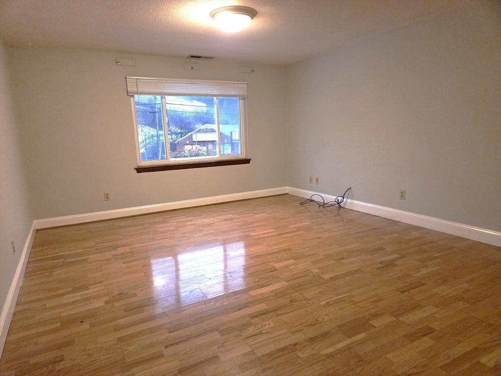 586 Boston Post Road East, Unit 6 Marlborough, MA 01752 - Photo 8 of 17 an empty room with wooden floor and windows
