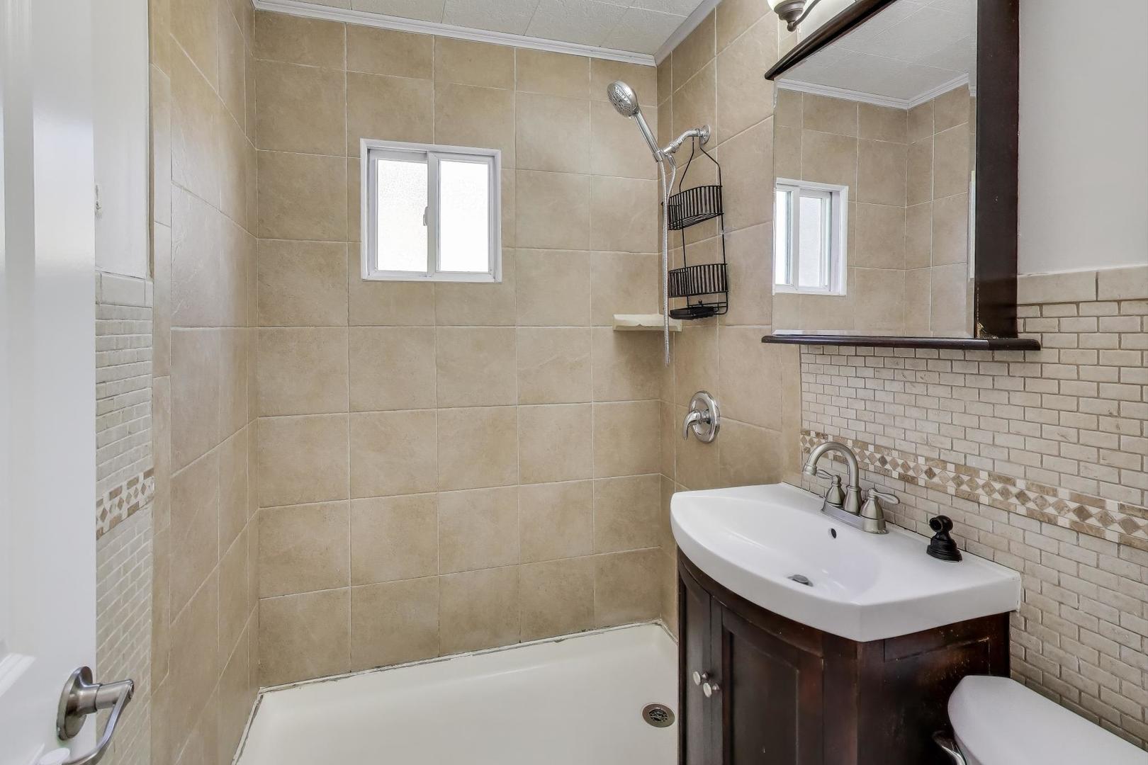 9454 Potter Road Des Plaines, IL 60016 - Photo 21 of 33 a bathroom with a sink toilet and mirror
