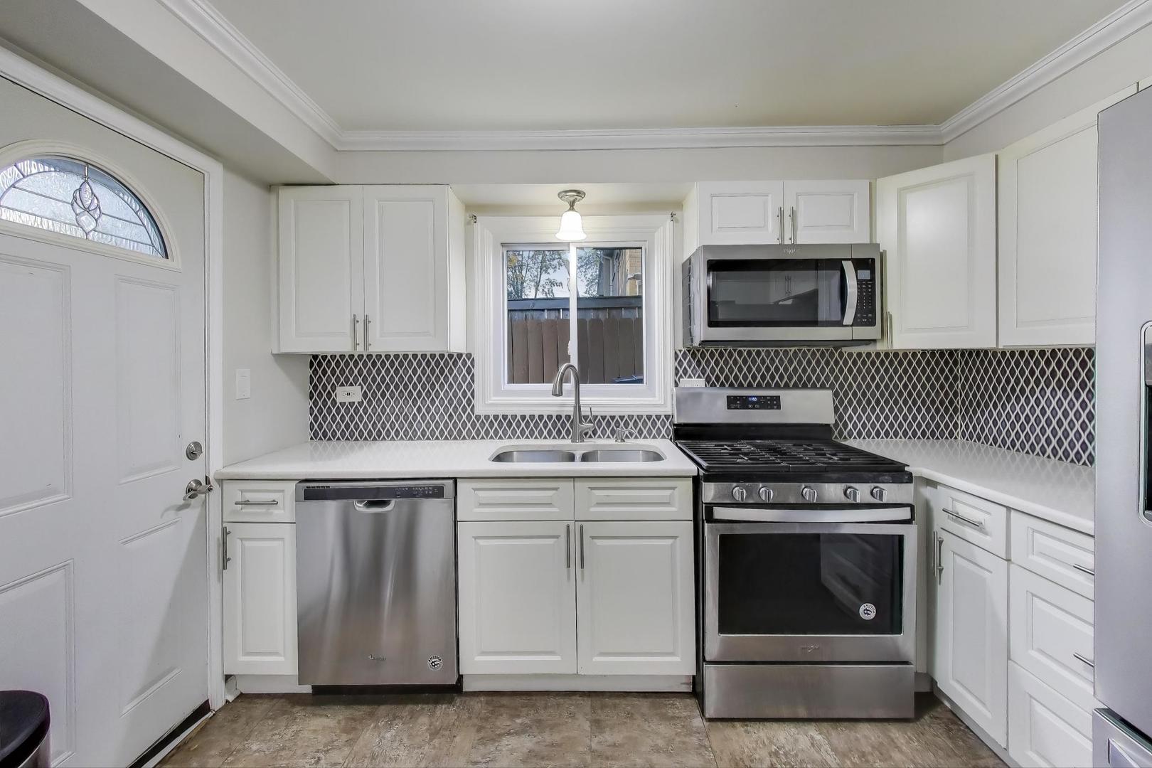 9454 Potter Road Des Plaines, IL 60016 - Photo 9 of 33 a kitchen with cabinets stainless steel appliances and sink