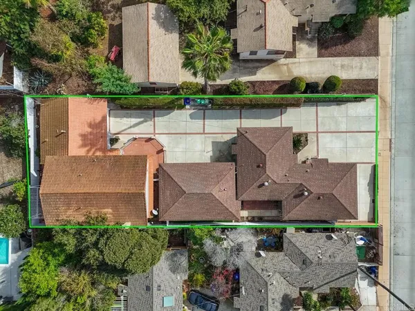 an aerial view of a house with a yard and large trees