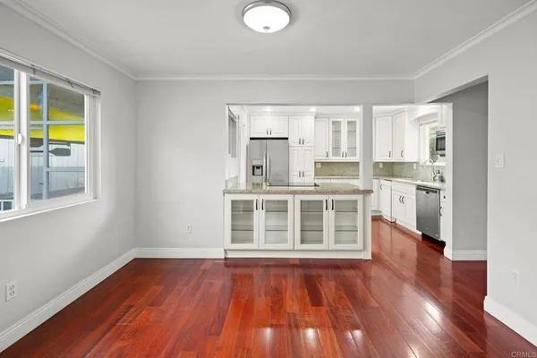 a view of a kitchen with wooden floor and a window