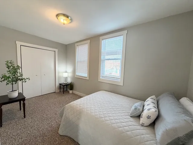 a bedroom with a bed and a potted plant