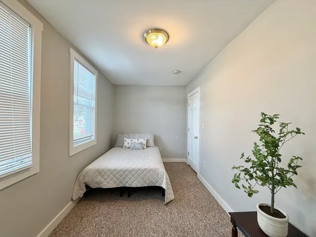 a bedroom with a bed and a potted plant