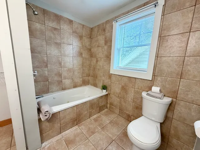 a white toilet sitting next to a white sink and vanity