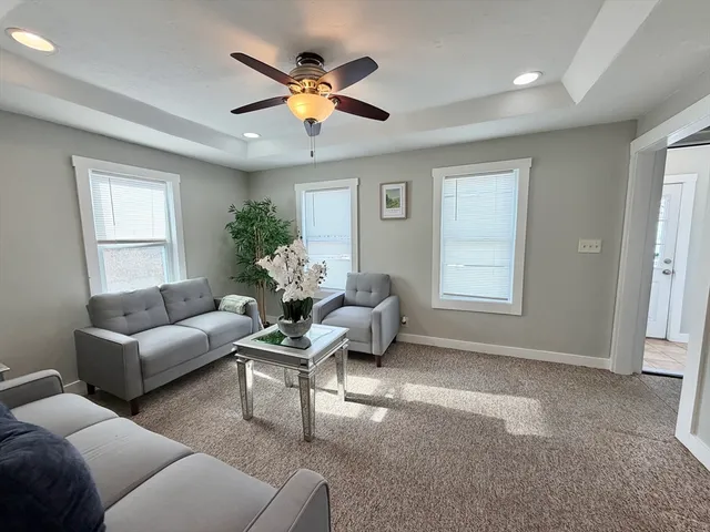 a living room with stainless steel appliances granite countertop a kitchen island hardwood floor sink stove dining table and chairs
