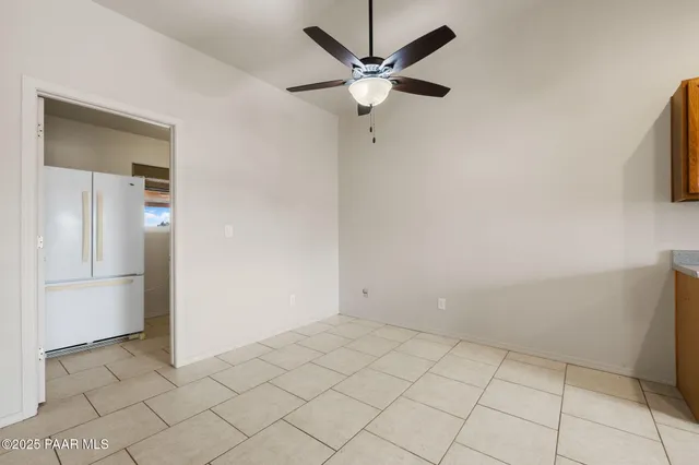 an empty room with a ceiling fan and a window