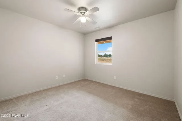 a view of empty room with a ceiling fan