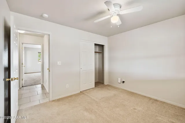 an empty room with fan and entrance