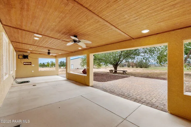 a view of a patio with table and chairs under an umbrella