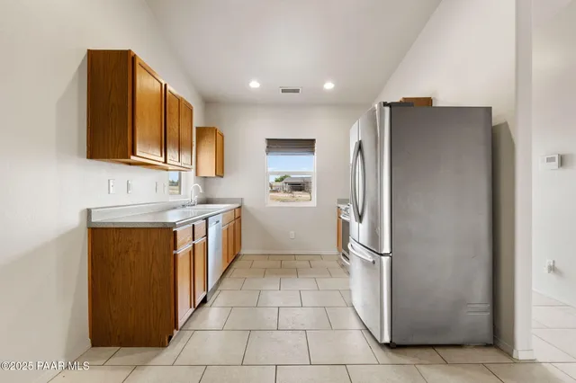 a kitchen with stainless steel appliances granite countertop a refrigerator and a sink