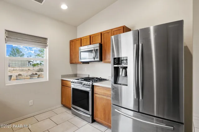 a kitchen with stainless steel appliances a refrigerator stove and microwave