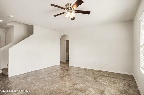an empty room with windows and fan