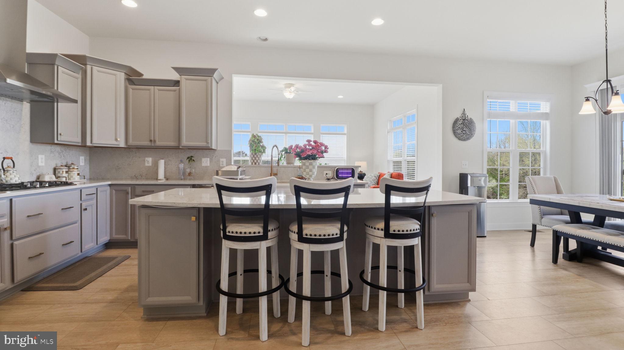 11502 Aden Road Nokesville, VA 20181 - Photo 36 of 106 a kitchen with granite countertop a table chairs stove and white cabinets