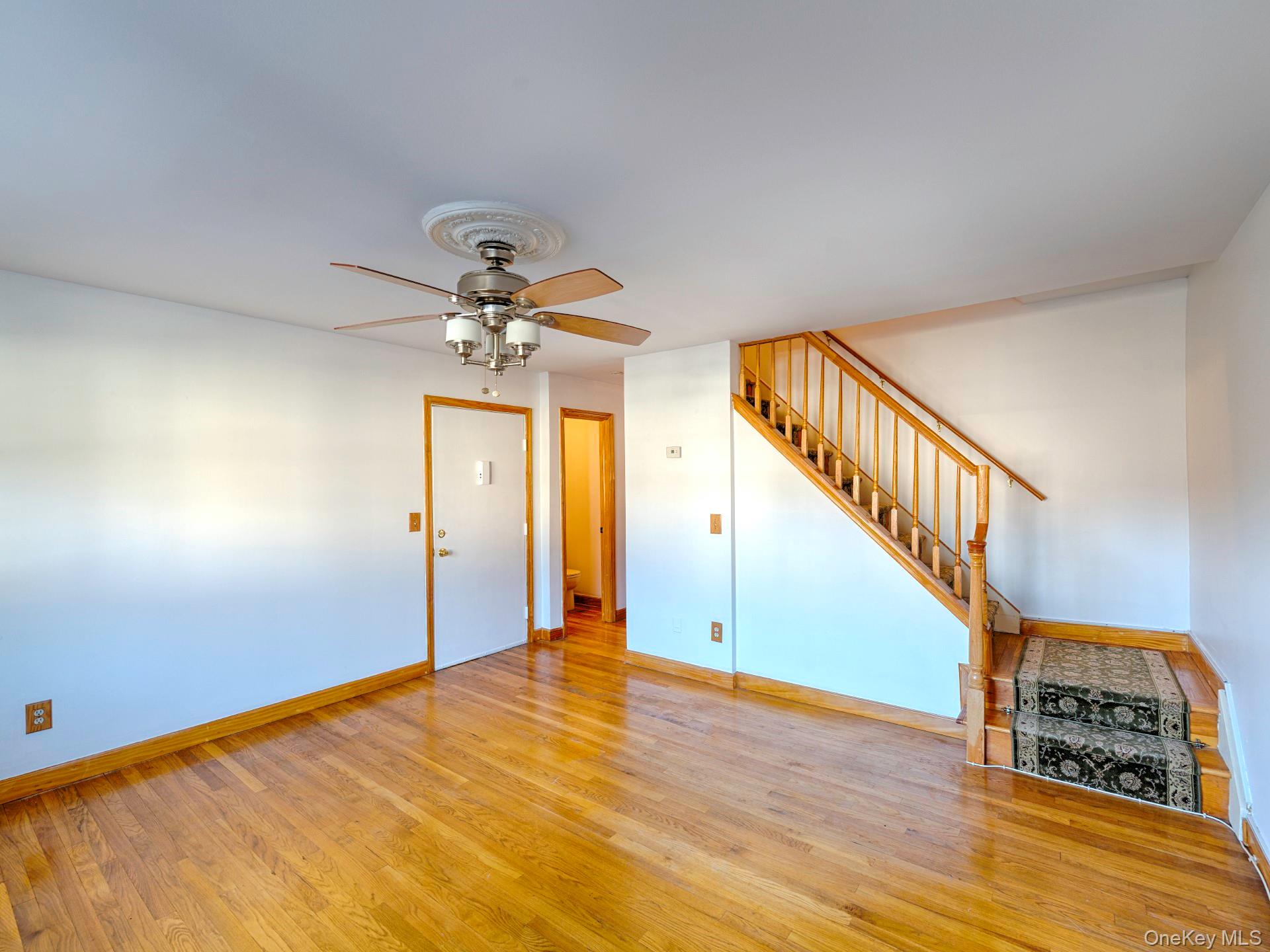 4 Forge Gate Drive, Unit F2B Cold Spring, NY 10516 - Photo 4 of 15 Unfurnished living room featuring wood finished floors, stairway, and ceiling fan