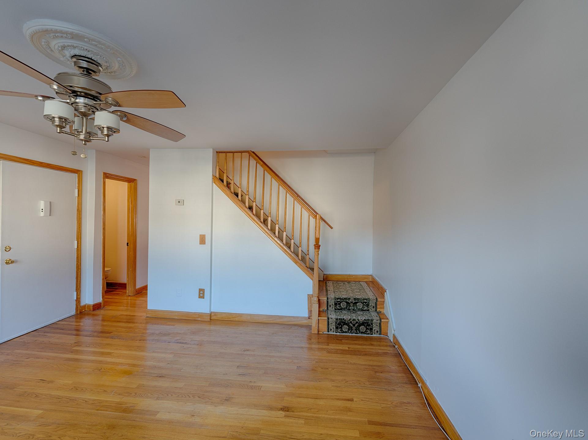 4 Forge Gate Drive, Unit F2B Cold Spring, NY 10516 - Photo 6 of 15 Unfurnished living room with light wood-type flooring, stairs, and ceiling fan