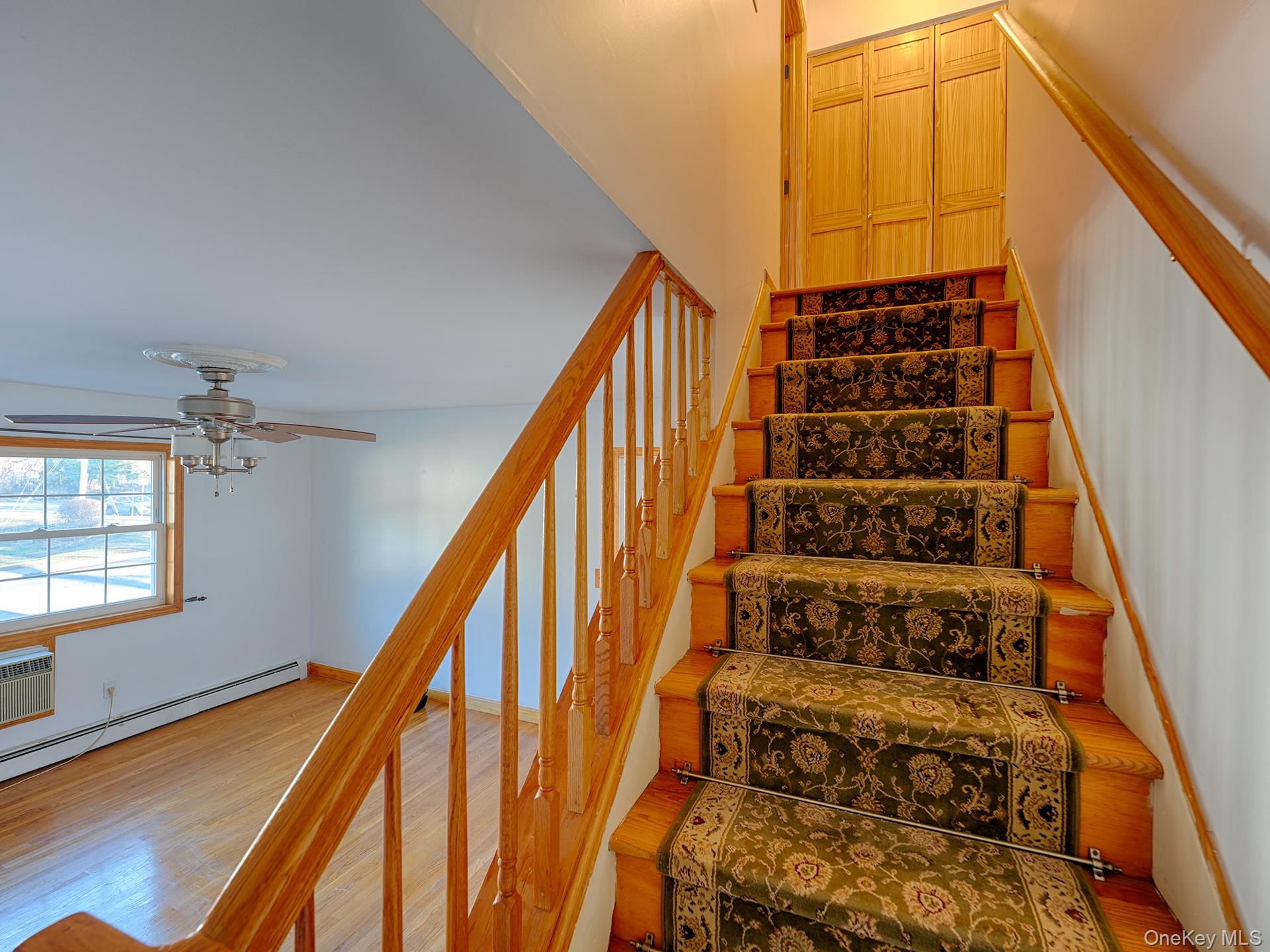 4 Forge Gate Drive, Unit F2B Cold Spring, NY 10516 - Photo 7 of 15 Stairs with wood finished floors, ceiling fan, and a wall mounted AC