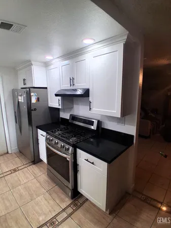 a kitchen with a stove a refrigerator and cabinets