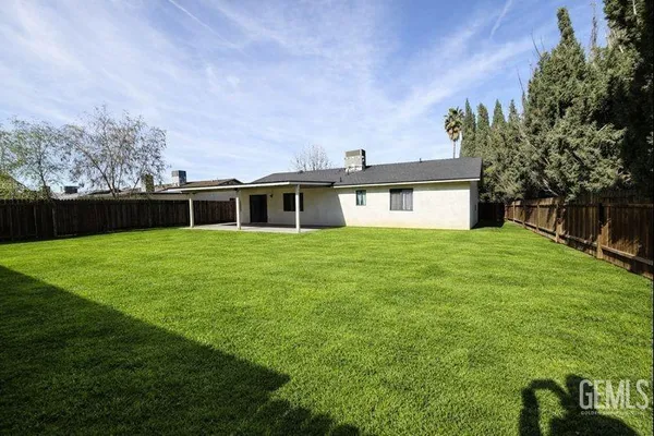 a view of a house with a yard potted plants and a tree