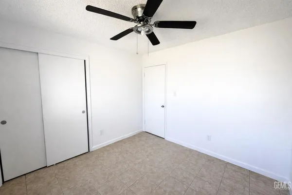 an empty room with a ceiling fan and a window