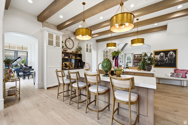 71 Farm Road Midway, UT 84049 - Photo 11 of 92 Gourmet kitchen featuring a substantial island with seating, integrated cabinetry, wood-finish flooring, exposed ceiling beams, and recessed lighting