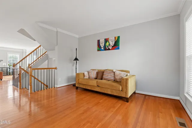 a living room with couches and a dining table with wooden floor