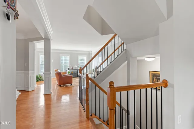 a view of staircase with lots of frames on wall and a wooden floor