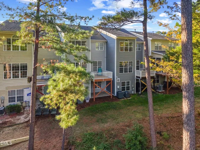 a view of a brick house with a yard and large tree