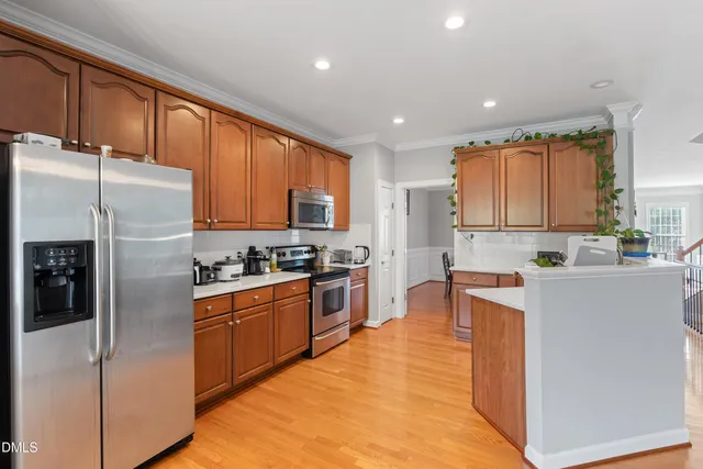 a kitchen with stainless steel appliances granite countertop a refrigerator stove top oven and sink