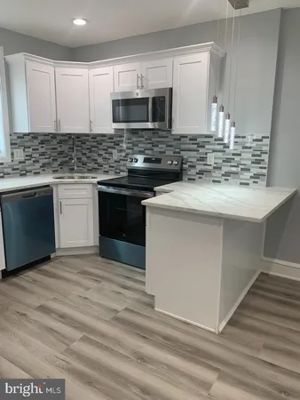 a kitchen with kitchen island granite countertop a sink stove and microwave