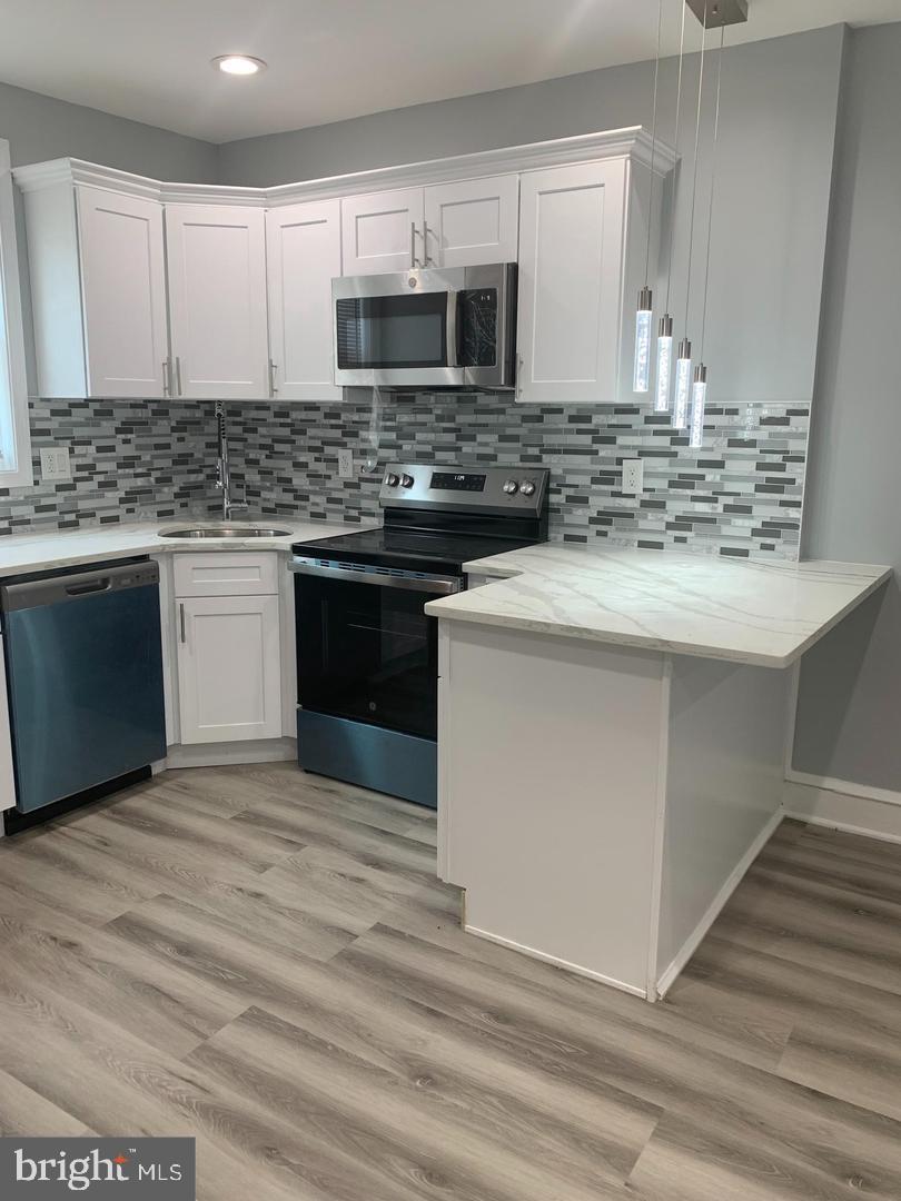 912 Anchor Street Philadelphia, PA 19124 - Photo 2 of 14 a kitchen with kitchen island granite countertop a sink stove and microwave