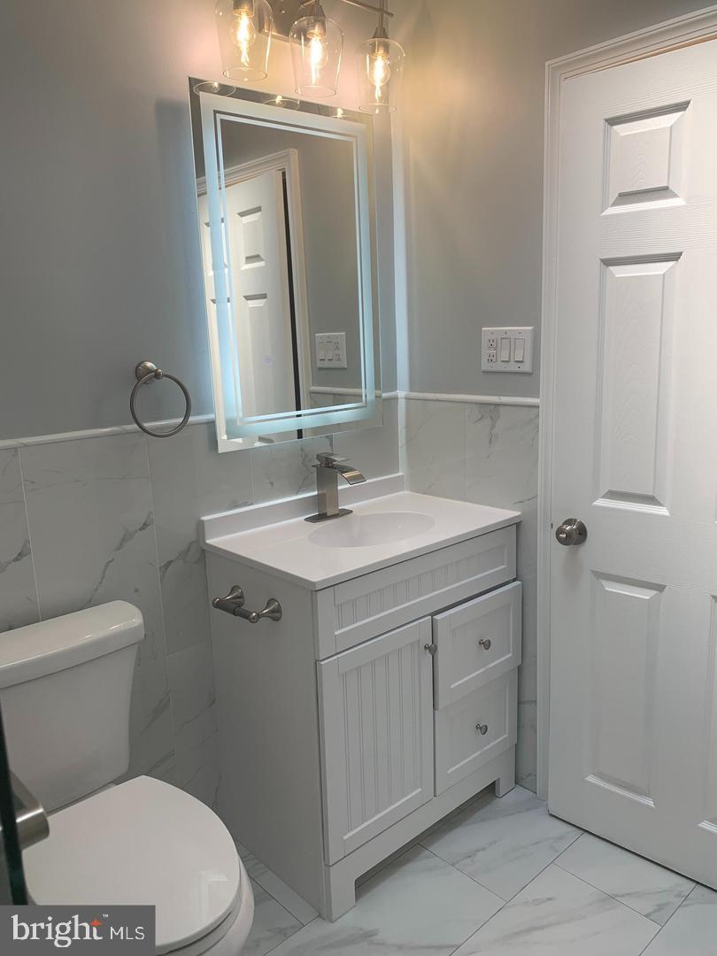 912 Anchor Street Philadelphia, PA 19124 - Photo 4 of 14 a bathroom with a toilet a sink a vanity and mirror