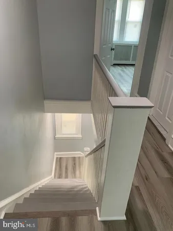 a view of staircase with railing and white walls