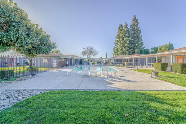 a view of house with backyard outdoor seating and entertaining space