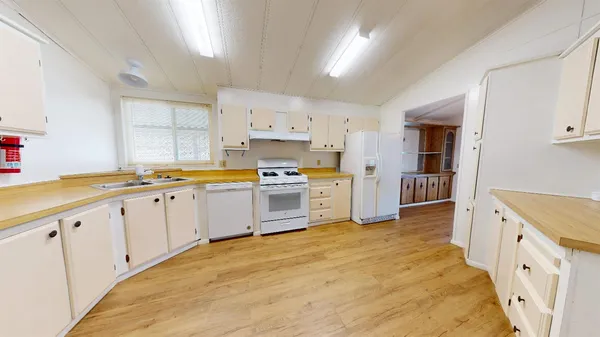 a large white kitchen with cabinets and stainless steel appliances
