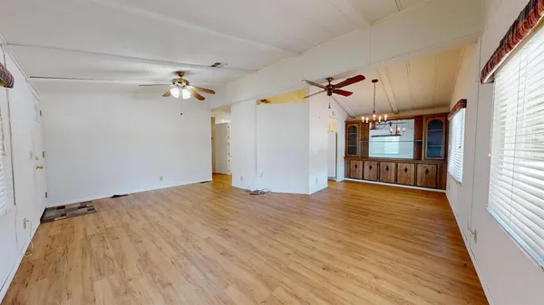 a view of a livingroom with wooden floor and a ceiling fan